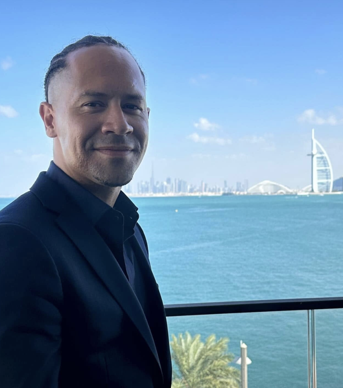 J.R. Lopez on a balcony overlooking the Dubai skyline and Burj Al Arab